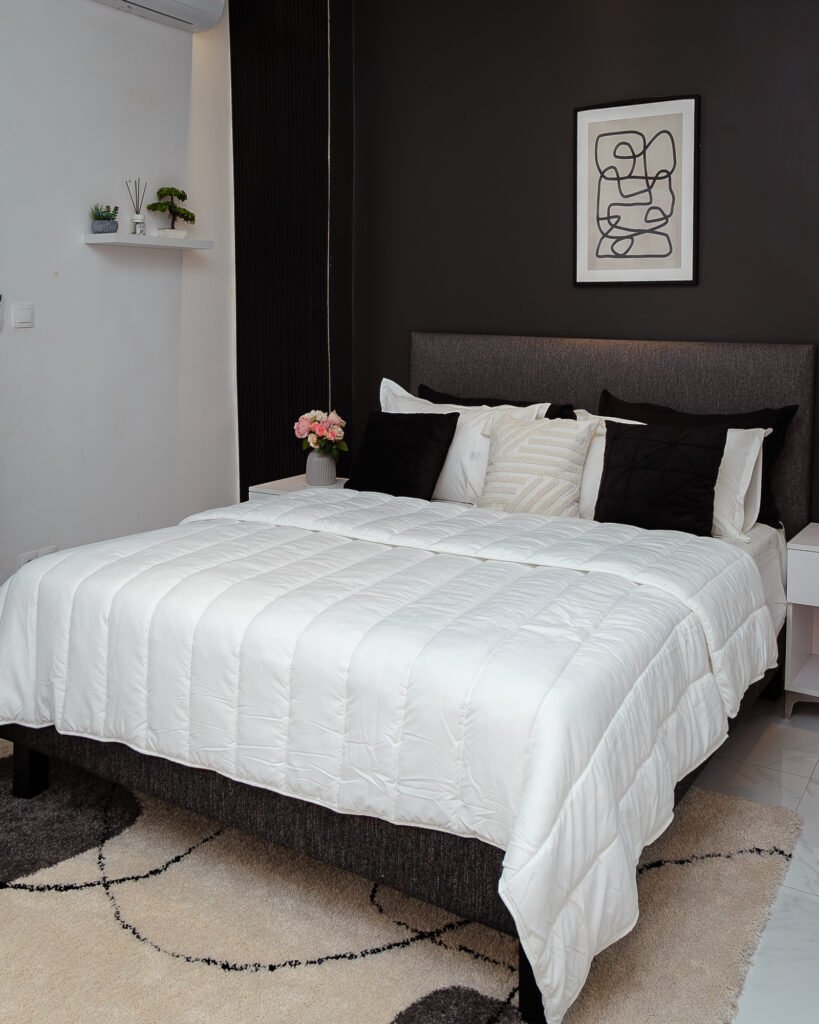 a bed with white sheets and pillows